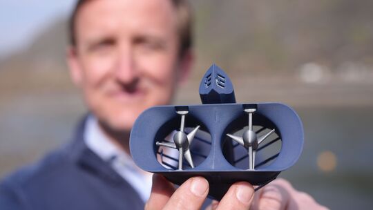 Georg Walder, Co-CEO der Energyminer GmbH, zeigt ein Modell der Turbine eines Schwarmkraftwerks, das im Rhein bei St. Goar arbei