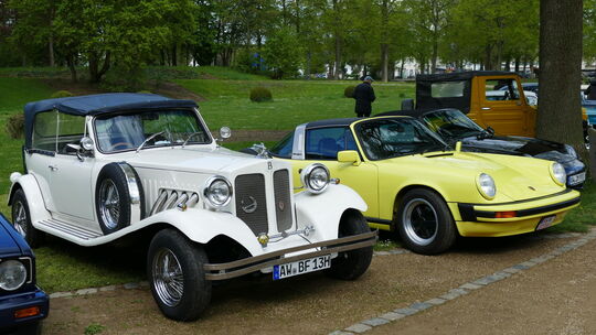 Ein weißer Oldtimer und ein gelber Youngtimer nebeneinander.