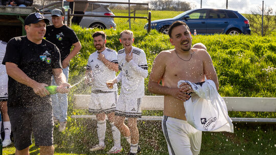 Sektdusche für den Meistertrainer: Marius Botiseriu (vorne) hat die SG Niederhambach/Schwollen zum B-Klasse-Titel und zum Aufsti