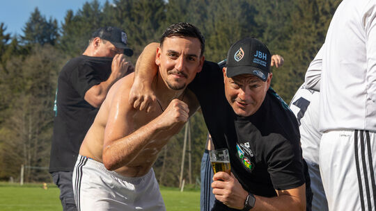 Der Meistertrainer der SG Niederhambach/Schwollen, Marius Botiseriu (links), feiert mit Jörg Jäkel, dem Vorsitzenden des SV Nied