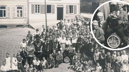 Kirmes in Hachenburg anno 1920: Der Kirmesbursche mit der Zieharmonika sitzt auf einem Bierfass mit der Angabe der Jahreszahl. Z