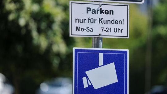 Ein Schild weist auf einem Supermarktparkplatz darauf hin, dass Parken nur für Kunden gestattet ist und der Platz videoüberwacht