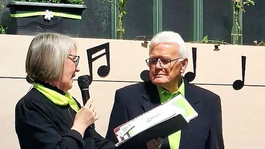 Die Vorsitzende des gemischten Chores Thalia Ebernhahn, Heidi Ambrus, dankt Norbert Görg für 75 Jahre Pflege des Chorgesanges in