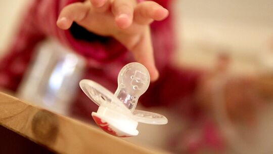 Kleinkind greift nach einem Schnuller