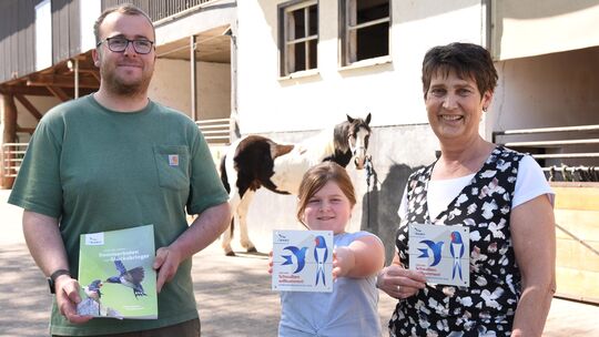 Felix Schön, Jolina und Martina Becker bei der Übergabe der Plakette "Schwalbenfreundliches Haus".