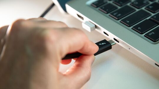 USB-C Ladebuchse und Ladekabel an einem Laptop