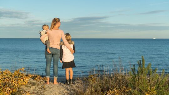 Eine Frau mit ihren Kindern an der Ostsee