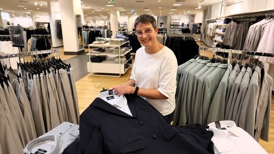 Männermode bei C&A in Neuwied: Verkäuferin Conny Holzappel hält einen dunklen Anzug in den Händen, für den Abi-Ball geht der Tre