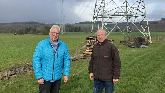 Reiner Wolf (links) und Karl-Heinz Saischek vor einem der Bestandsmasten, die in unmittelbarer Nähe der Wohnbebauung um Cramberg