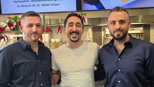Devrim (links) und Deniz Basibüyük (rechts) freuen sich über den Besuch von Rapper und Schauspieler Eko Fresh im Rhodos Grill in