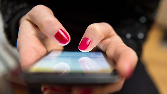 Eine Frau tippt auf einem Smartphone: Love Scamming nennt sich die Betrugsmasche, bei der die Täter über viele Wochen eine Bezie