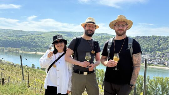 Der Mittelrheinische Weinfrühling lockt Besucher aus nah und fern in den Bopparder Hamm. Diese drei Wanderer genießen Wein, Sonn