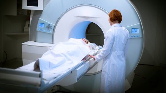 Ärztin bereitet eine Patientin für ein MRT vor