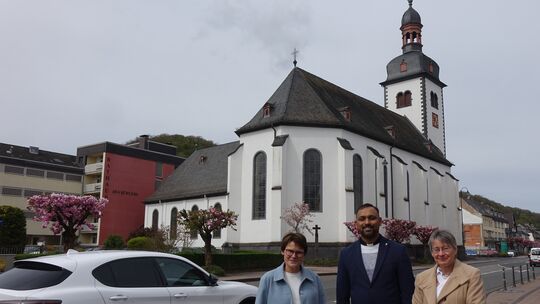 Foto an der B9 mit der katholischen Kirche Maria Himmelfahrt im Hintergrund (von links): Gemeindereferentin Josefine Bonn, Pater