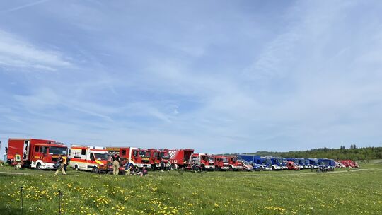 Dutzende Einsatzfahrzeuge stehen am Samstag aufgereiht am Waldrand nahe des Friesenhagener Weilers Kappenstein und lassen die Di