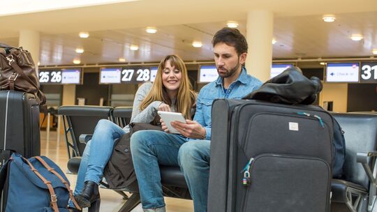 Ein Paar sitzt am Flughafen in der Check-In-Halle