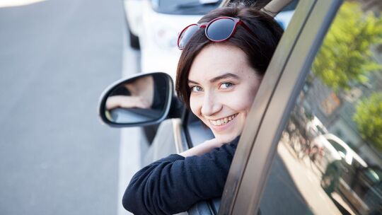 Eine junge Frau schaut aus einem Autofenster