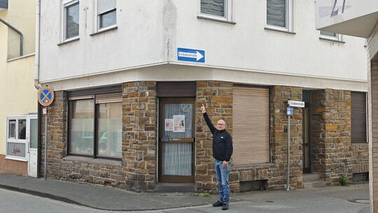 Ortsbürgermeister Oliver Labonde zeigt auf Reparaturspuren am Haus Hauptstraße/Ecke Grabenstraße.