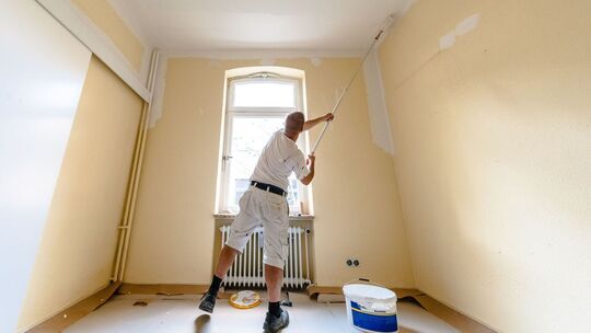 Maler streicht das Zimmer einer Wohnung Maler streicht das Zimmer einer Wohnung