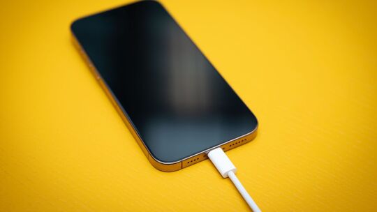 Ein iPhone mit schwarzem Bildschirm an einem USB-C-Kabel