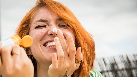Eine Frau trägt Sonnencreme auf