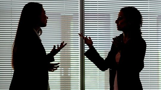 Zwei Frauen gestikulieren im Büro
