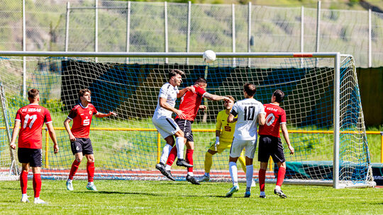 Urbars Kapitän Rinor Berbatovci (am Ball, rotes Trikot) köpft den Ball im Spiel gegen Oberwesel aus der Gefahrenzone. Gegen den