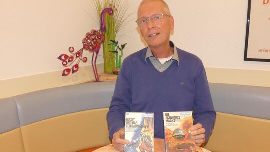 Holger Schmidt präsentiert Taschenbücher und Romanhefte der Perry-Rhodan-Reihe, die sein Vater Klaus Schmidt einst im Café Wonsy