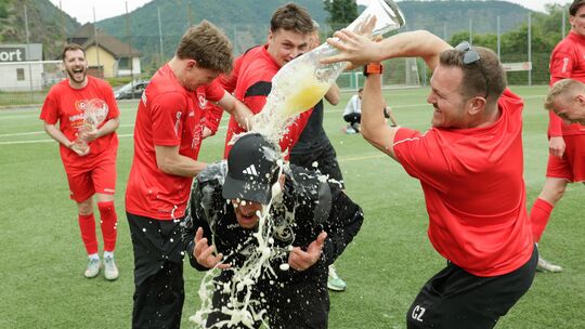 Tobias Wirtz, Teil des Trainergespanns des SV Untermosel, erhält von seinen Spielern die Meister-Dusche.