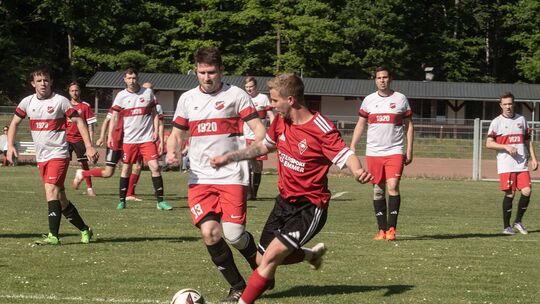 Der Rehborner (rotes Trikot) ist den berühmten Schritt schneller am Ball. Der Sponheimer kann ihn nicht am Torabschluss hindern.