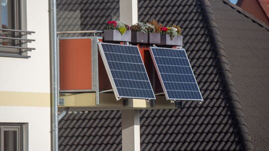 Solarmodule für ein Balkonkraftwerk hängen an einem Balkon