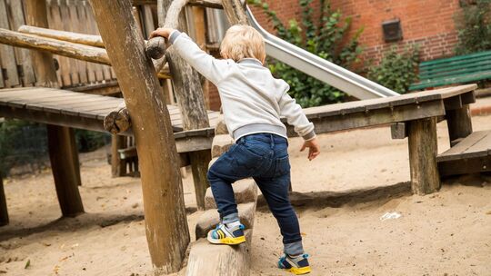 Junge spielt auf einem Spielplatz