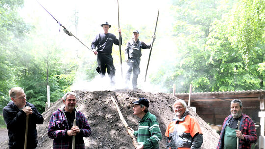 In sorgfältiger Handarbeit wurde im Rheinbrohler Wald ein Meiler errichtet, um auf traditionelle Weise Holzkohle herzustellen.