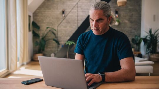 Mann arbeitet an einem Laptop Mann arbeitet an einem Laptop