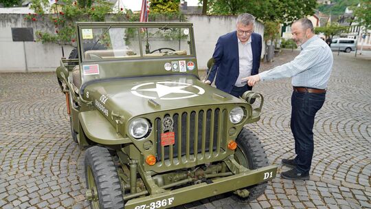 Moderator Ulrich Linnemann und Referent Stefan Michels vor einem historischen Jeep, der vor dem Nassau-Sporkenburger Hof abgeste