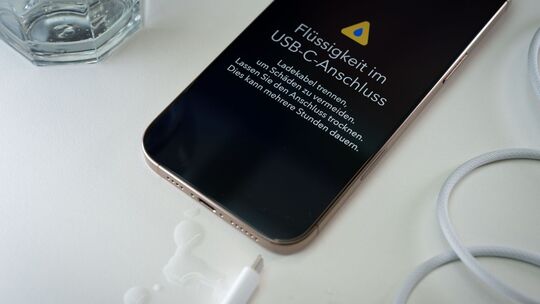 Ein iPhone mit einer Flüssigkeitswarnung und Wassertropfen