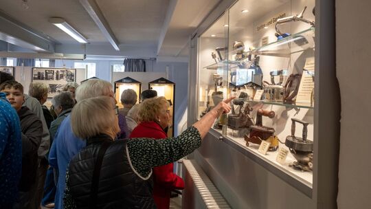 Die Besucher staunen über die Vielfalt an Bügeleisen und Glättgeräten in der Ausstellung.