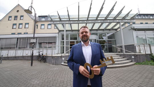 Bürgermeister Christoph Mohr hält den symbolischen Schlüssel für die ehemalige orthopädische Fachklinik in der Bendorfer Innenst
