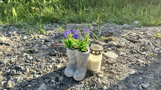 Blümchen und eine Kerze stehen nahe der Stelle am Ebernhahner Ortsrand, an der eine 67-Jährige grausam getötet wurde.