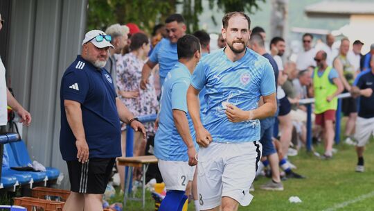 Dirk Reidenbach (in dunkelblau) grinst Tobias Schleich hinterher, der gerade den FSV Blau-Weiss Idar-Oberstein zum Sieg geegen d
