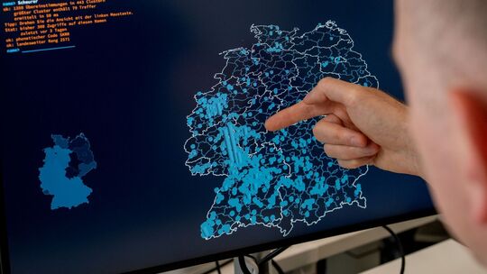 Ein Mann zeigt mit dem Finger auf einen Namenscluster Ein Mann zeigt mit dem Finger auf einen Namenscluster