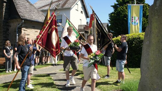 Im Rahmen des traditionellen Junggesellenfestes "Roeser Pfingsten" legen die Gastgeber zwei Blumengebinde im Gedenken an die Kri