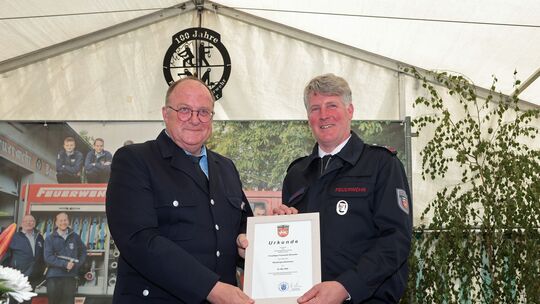 VG-Bürgermeister Guido Nisius überreicht eine Urkunde zum Jubiläum.