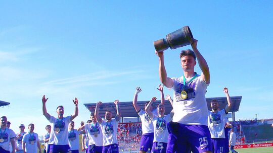 Da ist das Ding: Tristan Zobel stemmt den "Sachsen-Pokal" vor seinen Teamkollegen in die Höhe, der aus Emmelshausen stammende In