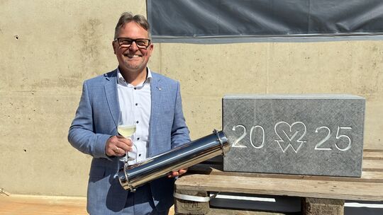 Carsten Berke, Vorstandsvorsitzender der Winzergenossenschaft Mayschoß-Altenahr, präsentiert den Grundstein für den Neubau. In s