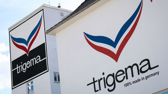 Das Logo der Textilfirma Trigema ist auf der Fassade des Firmensitzes zu sehen. Der Sportartikelhersteller eröffnet im Sommer ei