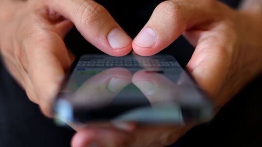 Ein Mann tippt auf einem Smartphone