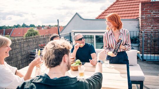 Eine Gruppe sitzt zusammen auf einer Dachterrasse