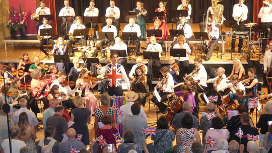 Zur Musik des Sinfonieorchesters schwenkten die Zuhörer die Fähnchen mit dem Union Jack, in den sich Dirigent Christian Ferel st