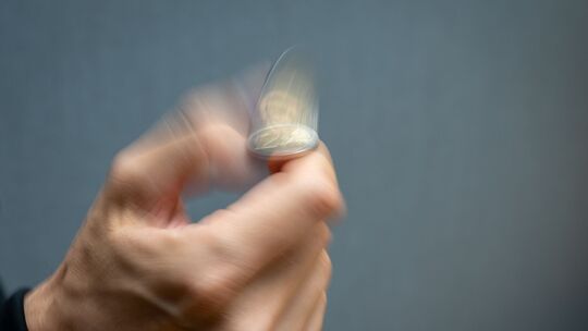 Ein Mann macht einen Münzwurf mit einer 2-Euro-Münze